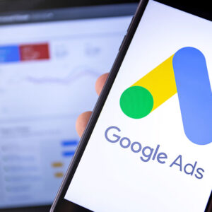 smartphone with Google Ads on the screen and display notebook ba smartphone with Google Ads on the screen and display notebook background. Ads is a service of contextual, basically, search advertising from Google. Moscow, Russia - August 25, 2019